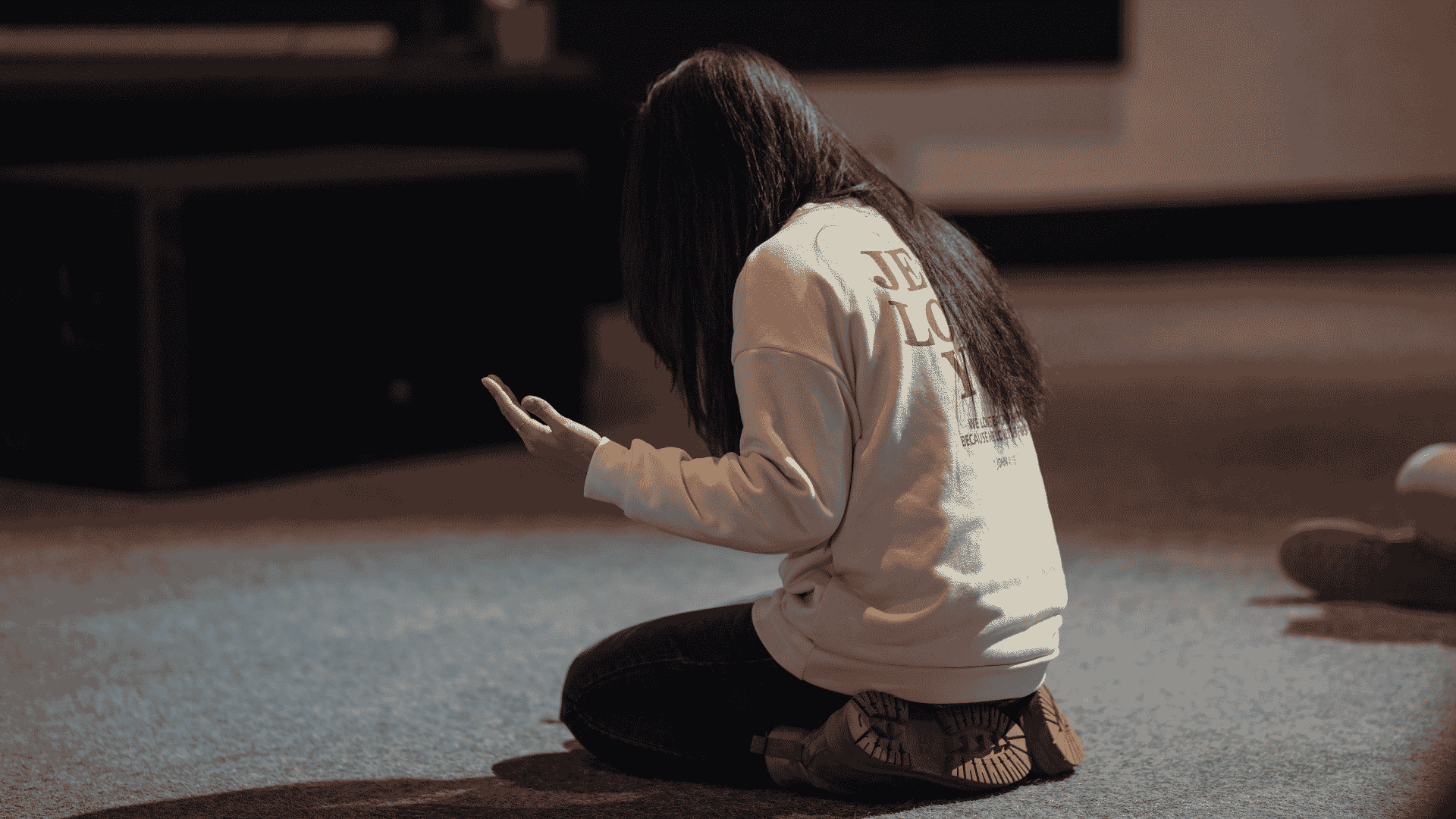 Woman praying on her knees with hands raised
